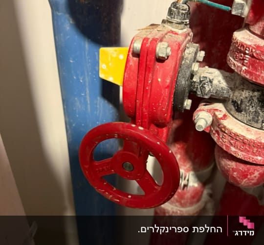 מגוף אדום ומד לחץ במערכת ספרינקלרים לכיבוי אש